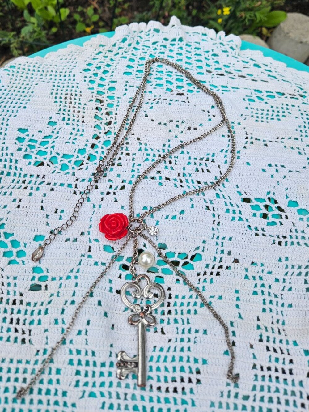 ALDO long silver-toned charm necklace with red rose, key charm, pearlesque stone